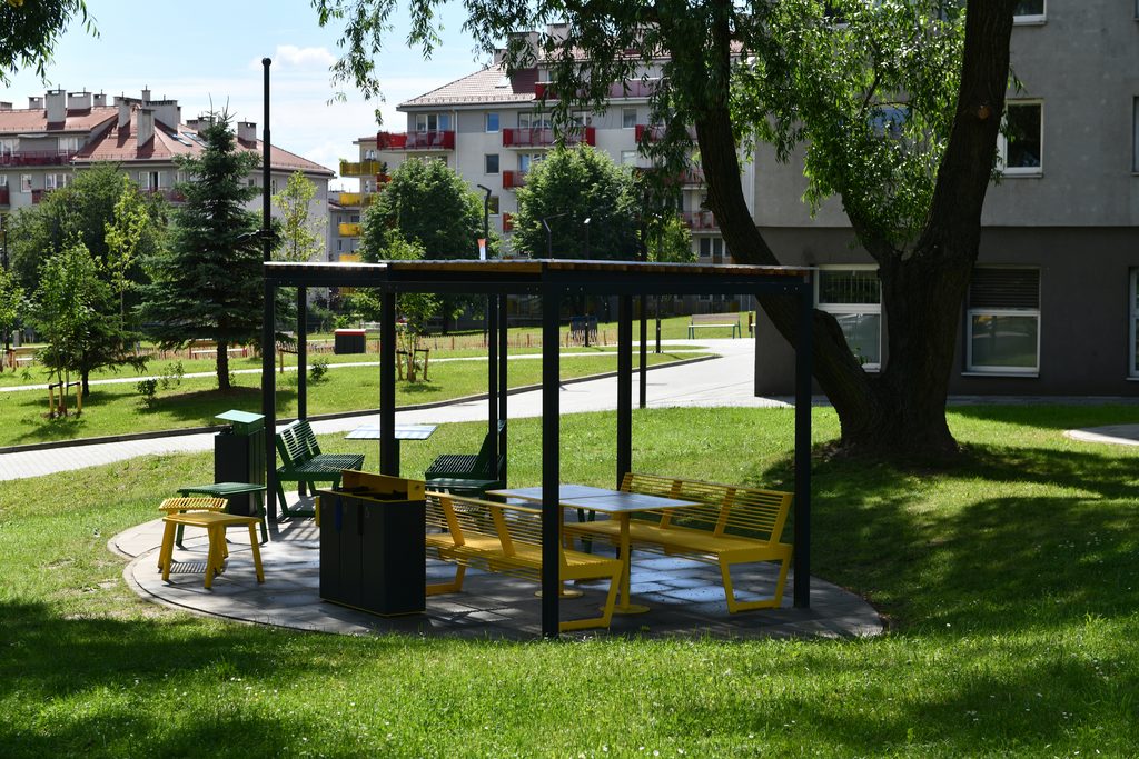 Altanka z kolorowymi siedzeniami w otoczeniu zieleni
