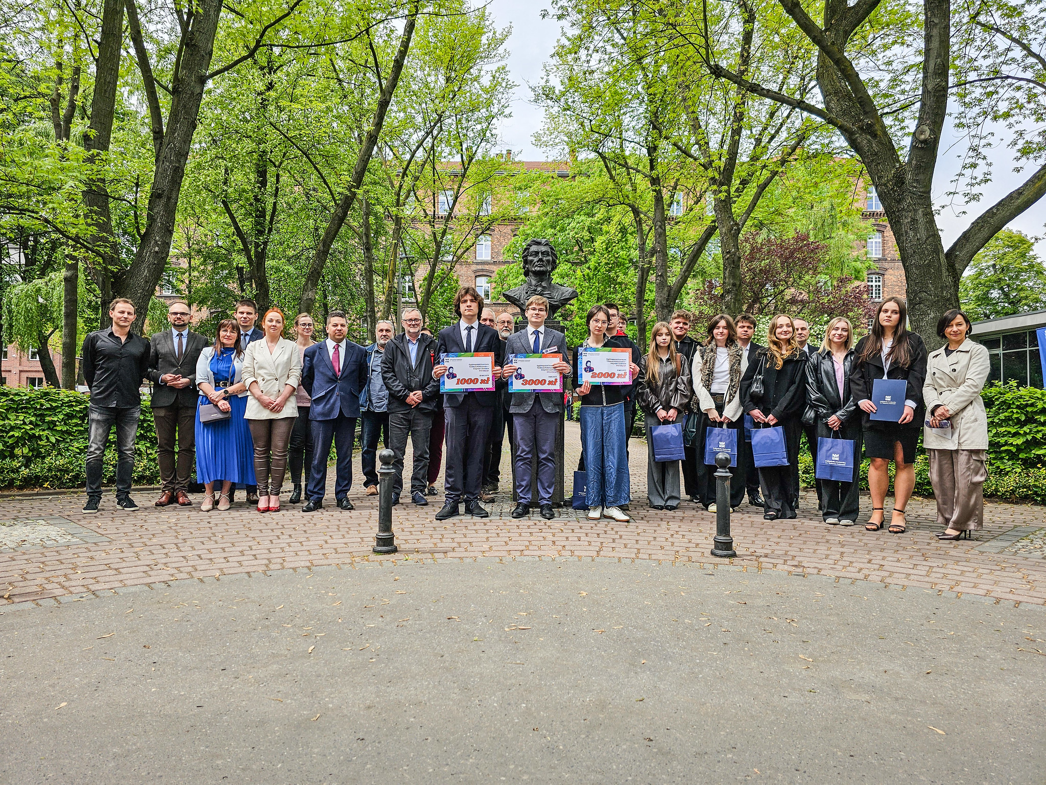 Uczestnicy finału pozują do wspólnego zdjęcia przy popiersiu Tadeusza Kościuszki