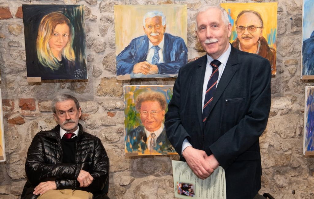 A room with stone walls, on which paintings hang