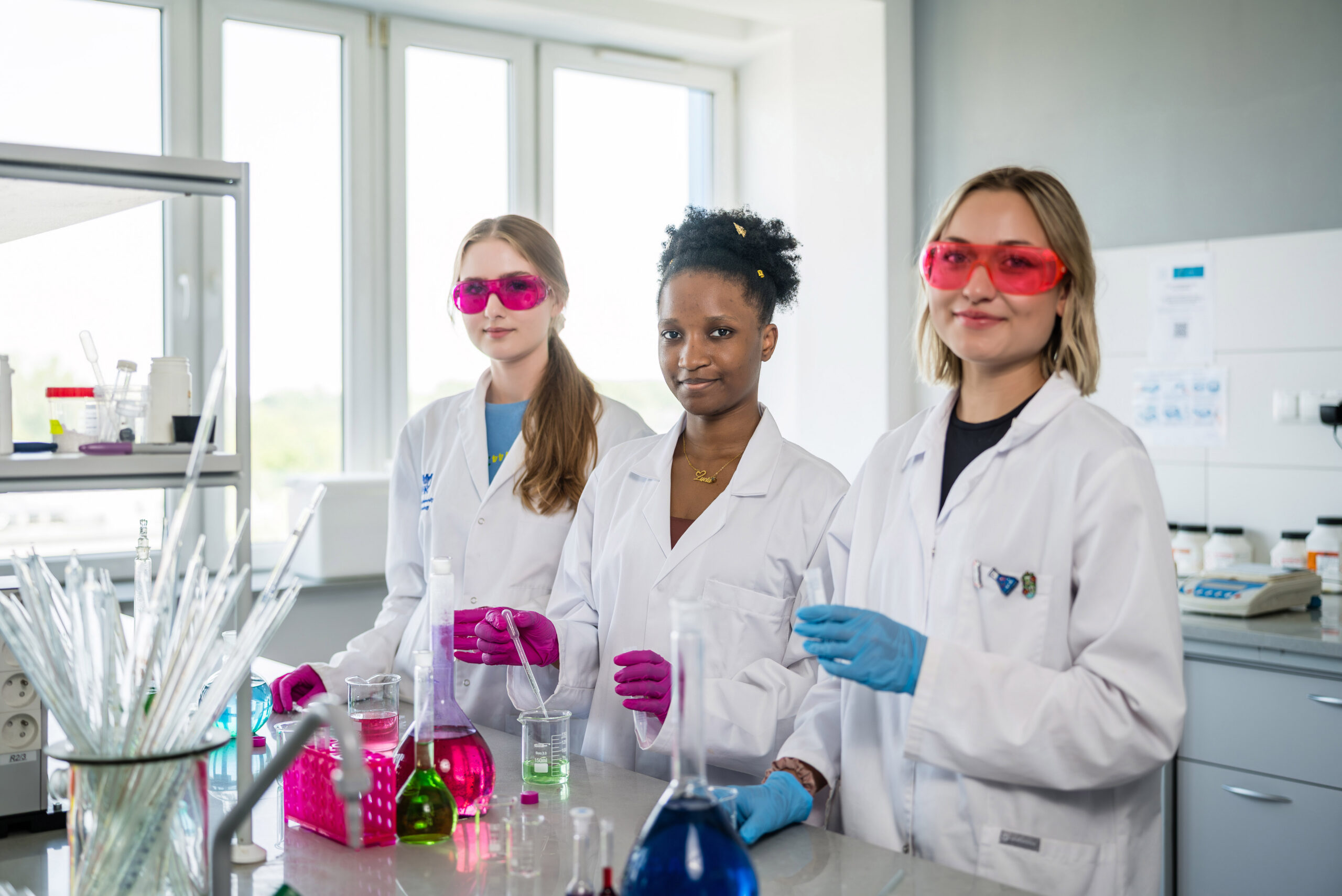 Three young scientists in chemistry laboratory