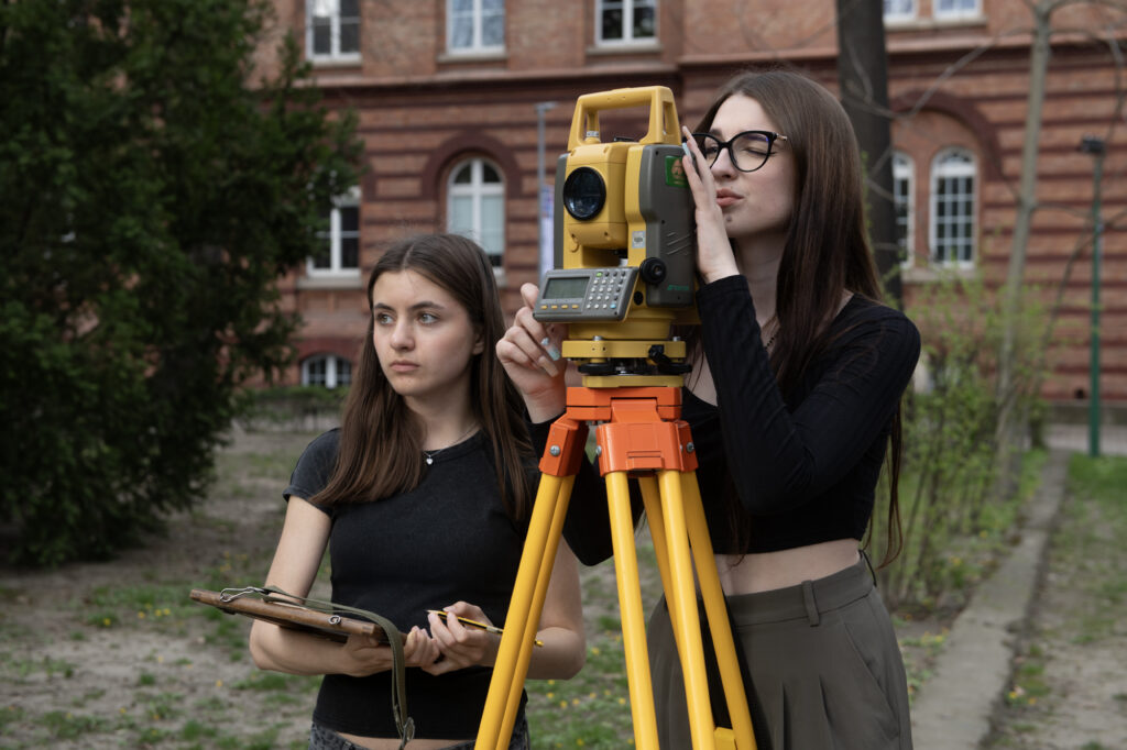 Students carrying out geodetic measurements using a geodetic measurement device