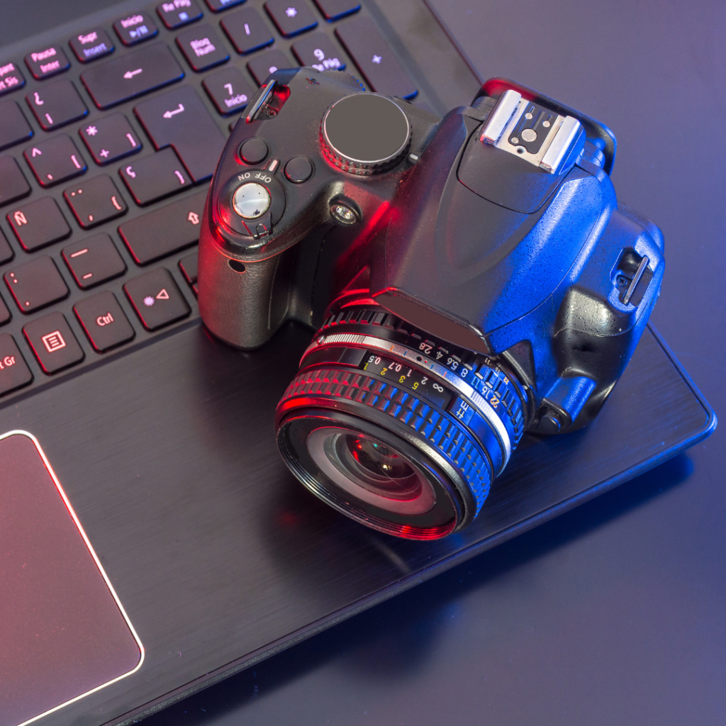 Ma laptopie leży profesjonalny aparat fotograficzny